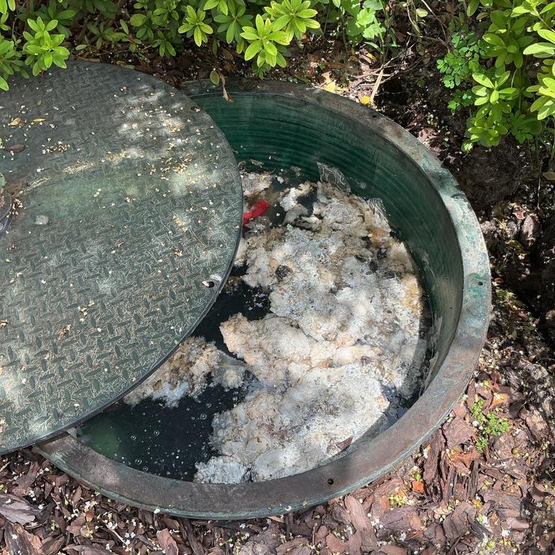 Lift station basin with foam buildup and open cover Lift station basin with foam buildup and open cover