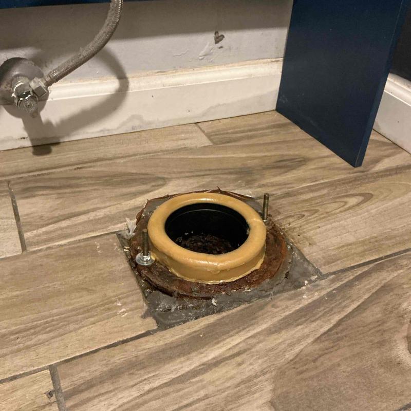 Toilet flange with new wax ring on tile floor
