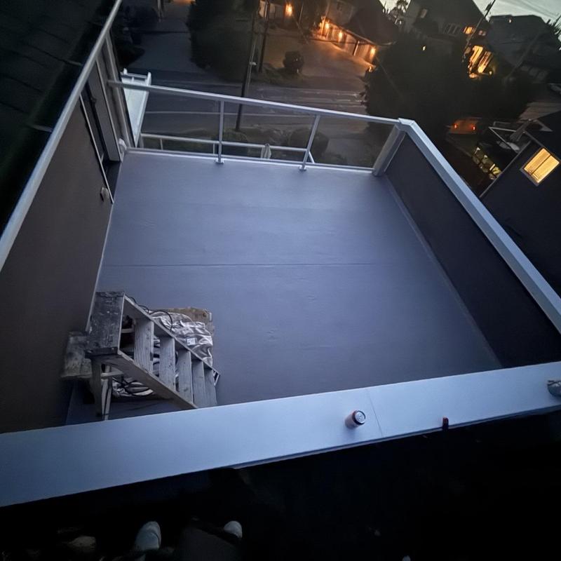 Flat roof replacement with railing installation at dusk