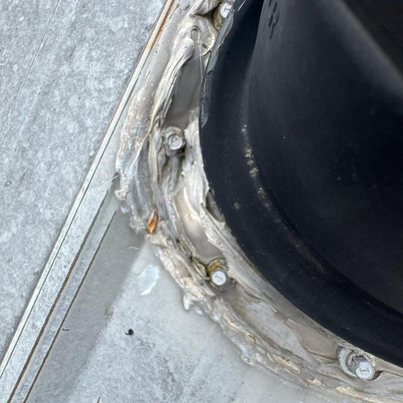 Roof flashing sealant around pipe base on metal roof