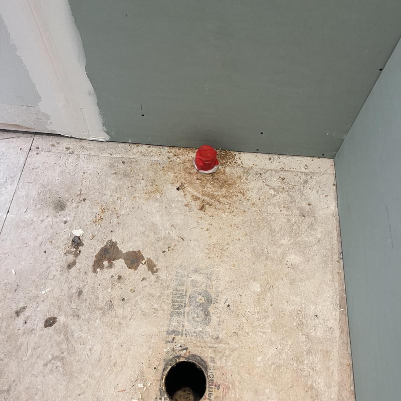 Shower drain relocation with capped pipe in floor