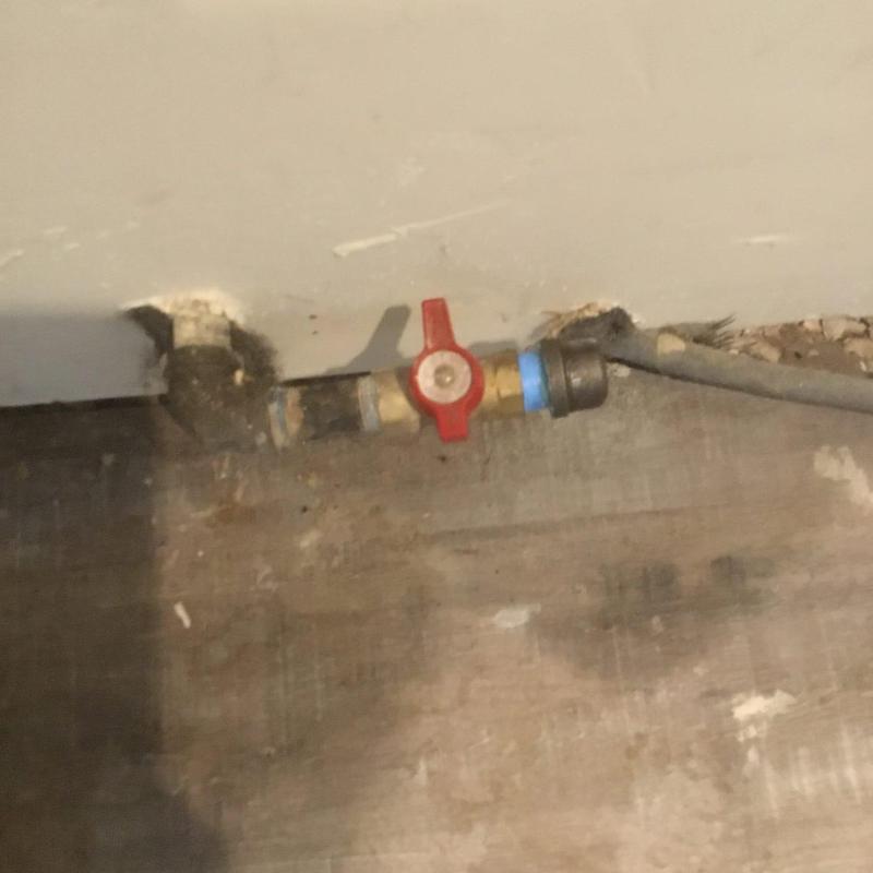 Gas valve with red handle behind stove area