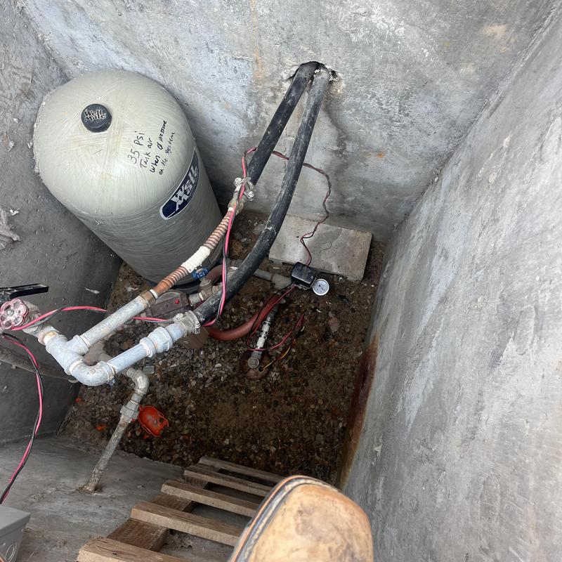 Well pressure tank and piping in concrete pit Well pressure tank and piping in concrete pit
