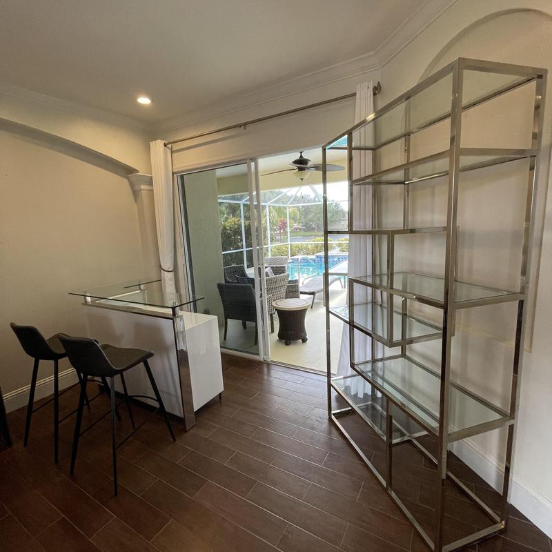 Glass metal shelving unit and bar counter in room