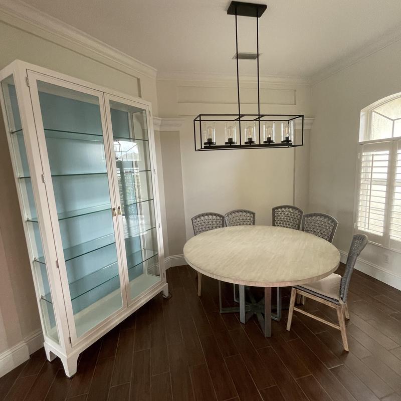 Glass display cabinet and round dining table in room
