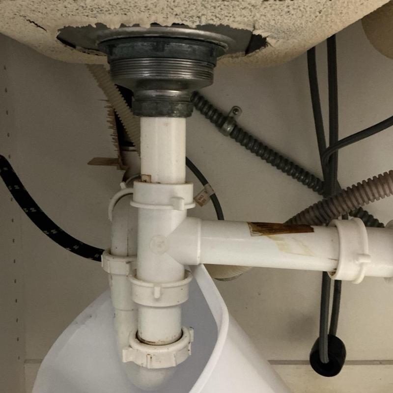 Kitchen sink drain pipe with cut drywall above Kitchen sink drain pipe with cut drywall above