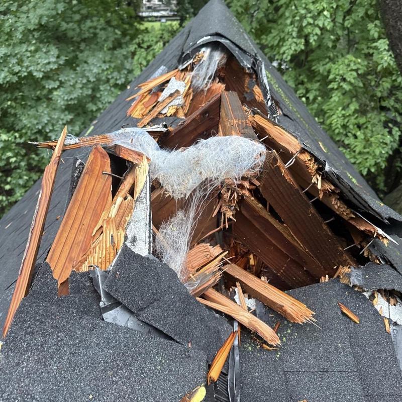 Roof shingles and wood storm damage with exposed framing Roof shingles and wood storm damage with exposed framing