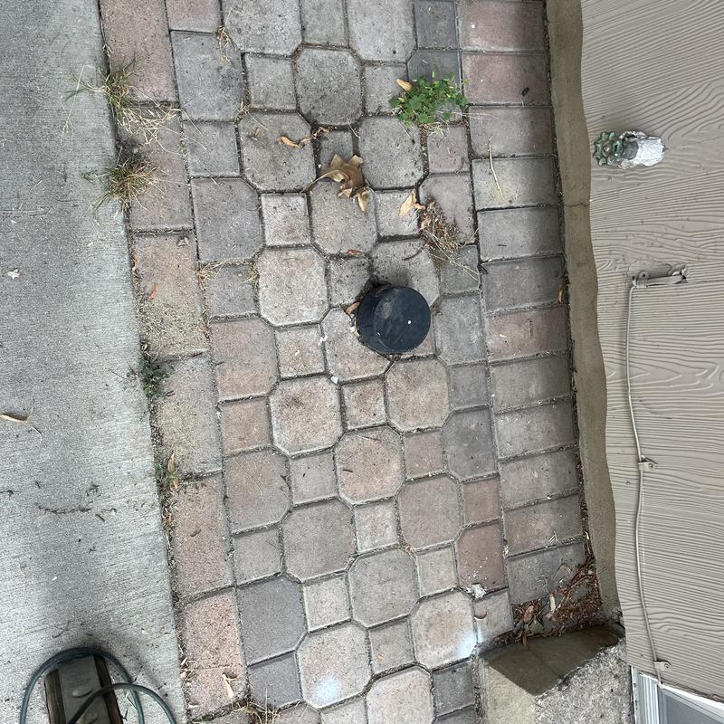 Sewer cleanout cap on outdoor brick patio near house wall Sewer cleanout cap on outdoor brick patio near house wall