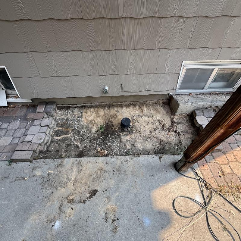 Sewer cleanout access with exposed soil and patio blocks Sewer cleanout access with exposed soil and patio blocks