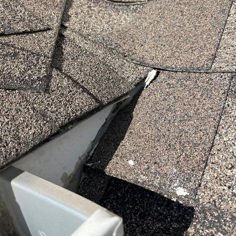 Roof shingles with hail damage near flashing edge