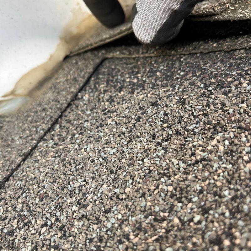 Asphalt shingles close-up showing hail damage and wear