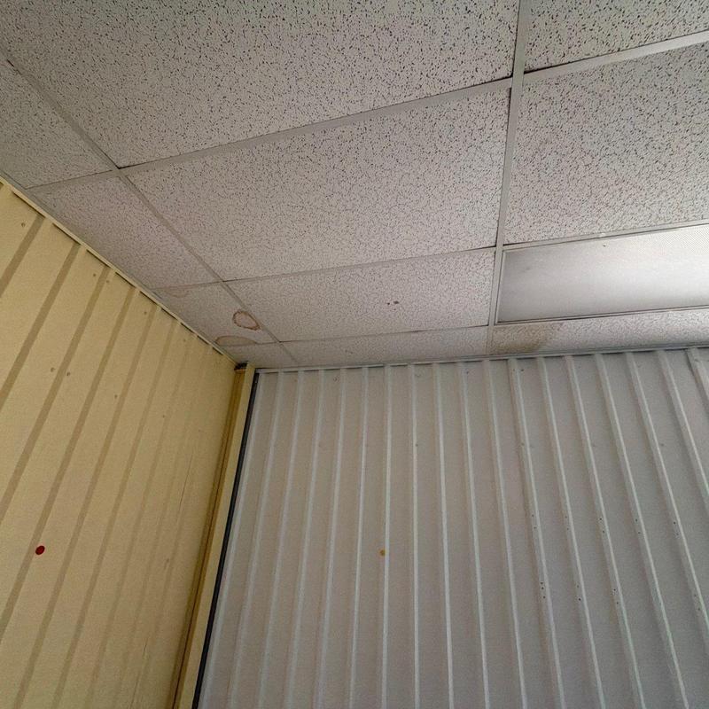 Drop ceiling panels with water stains and damage