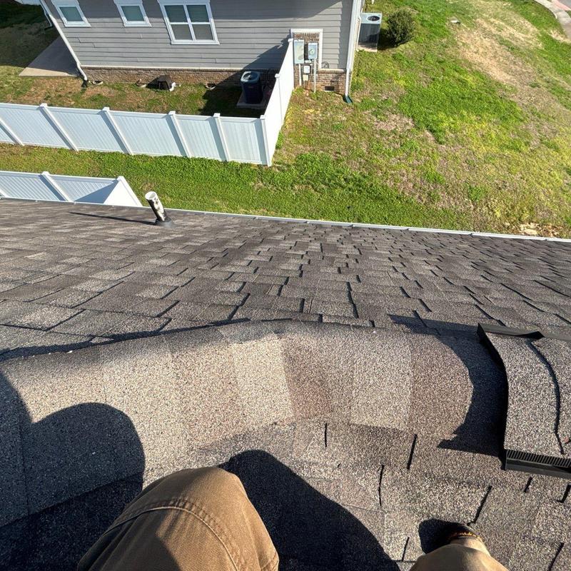 Asphalt roof shingles with visible hail damage area