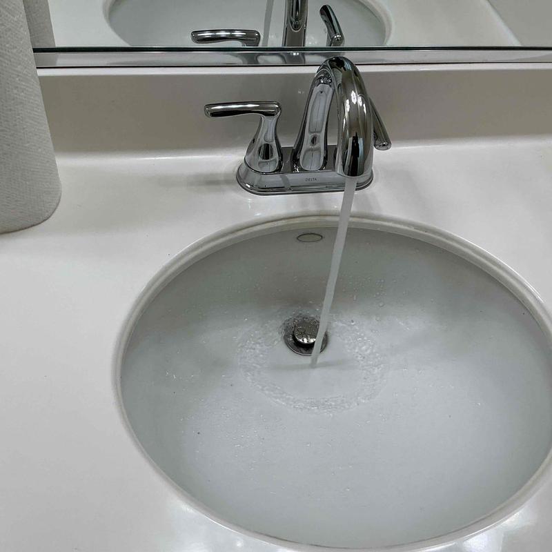 Bathroom faucet with running water and sink basin