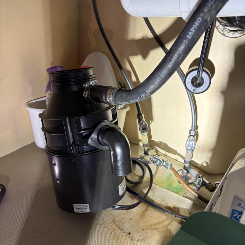 Garbage disposal with water supply hoses under sink Garbage disposal with water supply hoses under sink