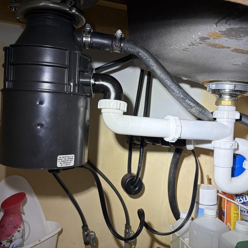Garbage disposal and PVC drain piping setup under sink Garbage disposal and PVC drain piping setup under sink
