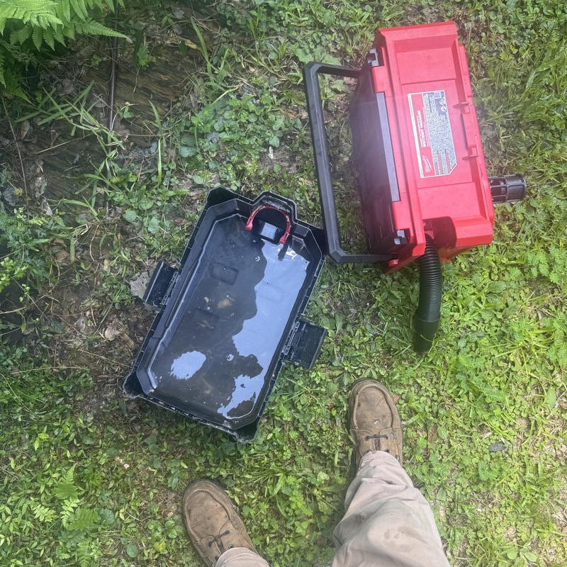 Heat pump drain line vacuum and water trap on grass