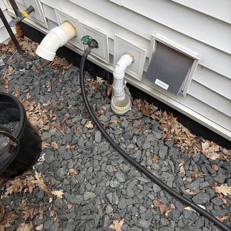 Sump pump discharge pipe with hose and valve outdoors Sump pump discharge pipe with hose and valve outdoors