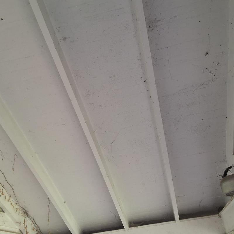 Porch ceiling beams with cobwebs and dirt buildup