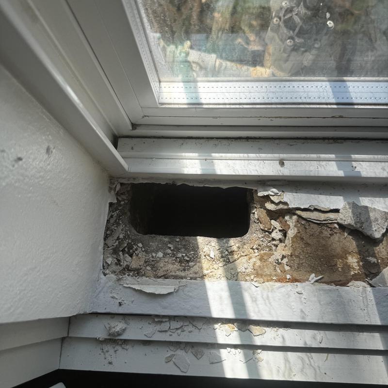 Window sill with damaged drywall and hole exposed