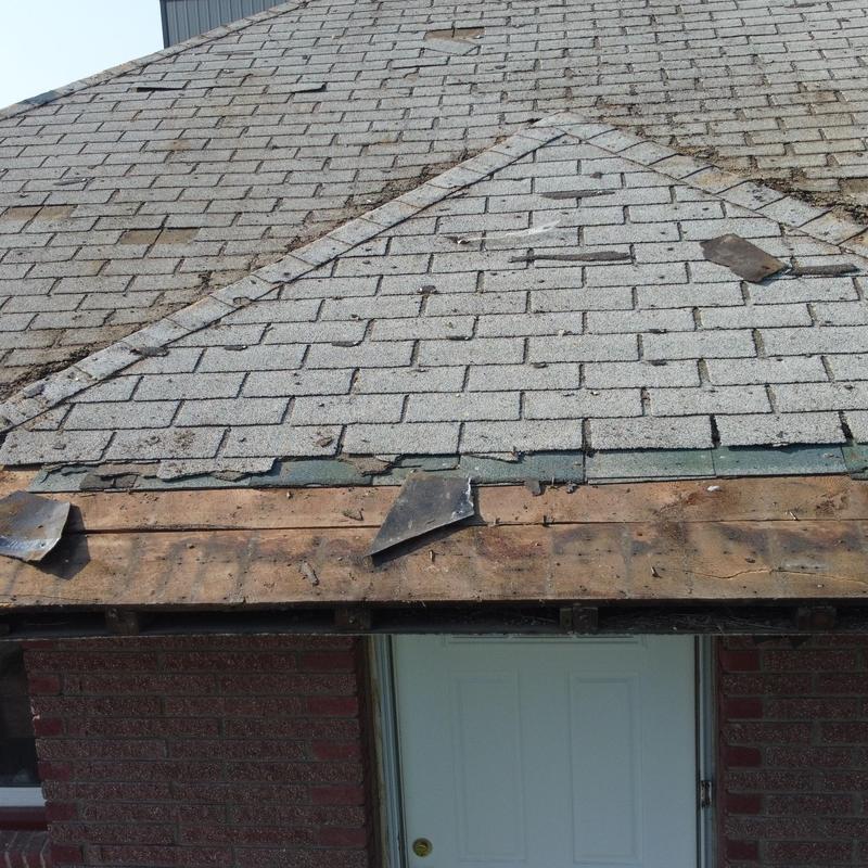Asphalt shingle roof with damaged edges over entrance door Asphalt shingle roof with damaged edges over entrance door