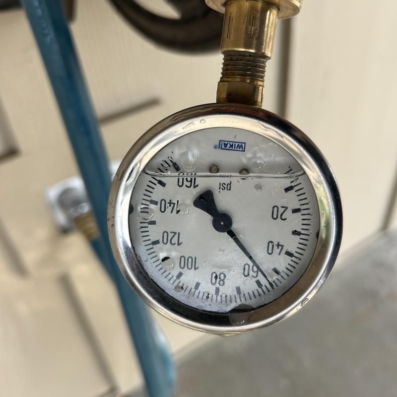 Water pressure gauge on plumbing pipe with moisture droplets Water pressure gauge on plumbing pipe with moisture droplets