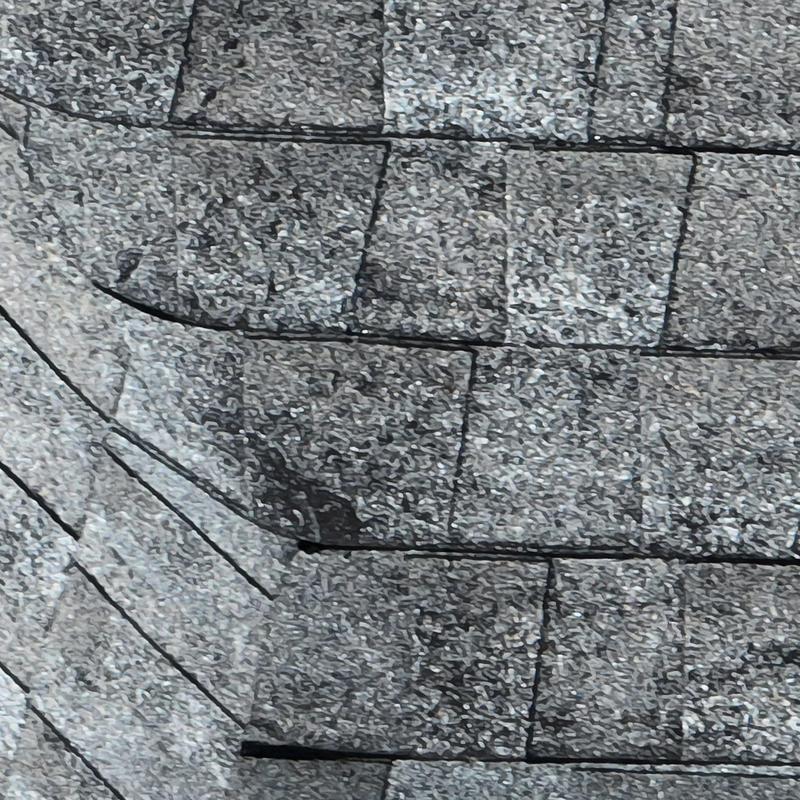 Asphalt shingles with hail damage on roof section