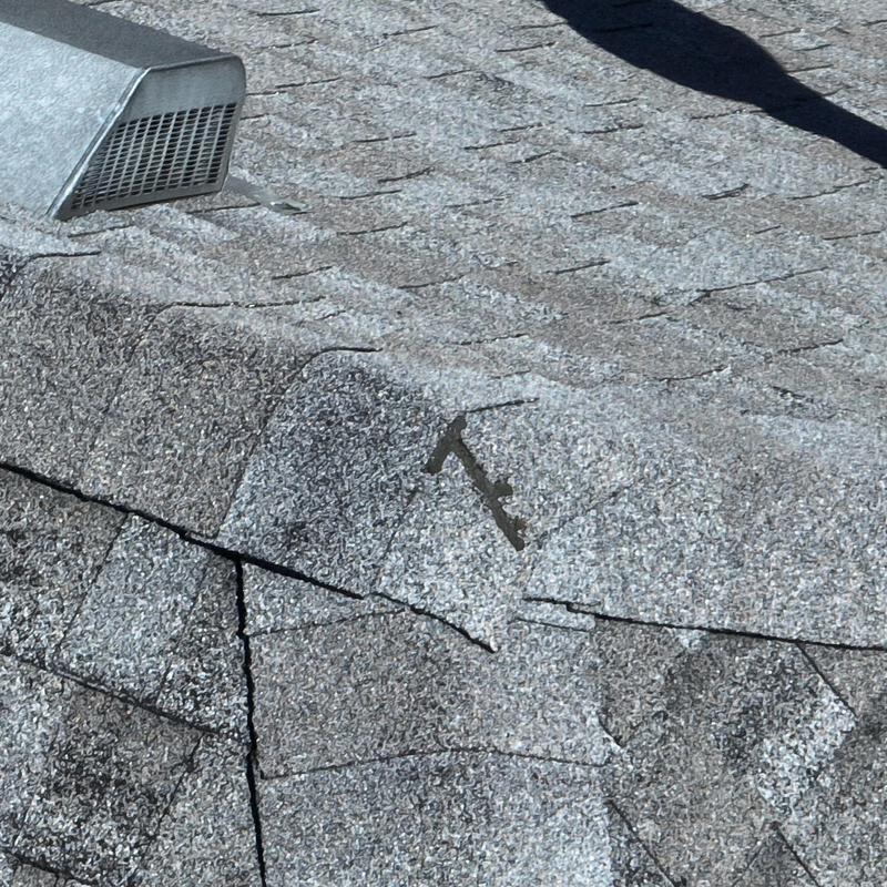 Roof shingles with hail damage near vent cover
