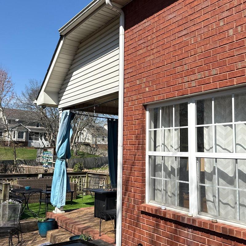 Vinyl siding and gutter inspection on brick home exterior