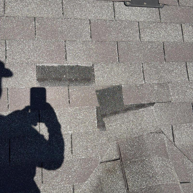 Asphalt roofing shingles with hail damage and wear
