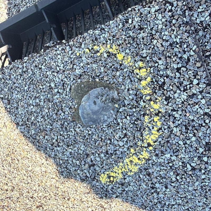 Roof shingle hail damage marked with yellow chalk circle
