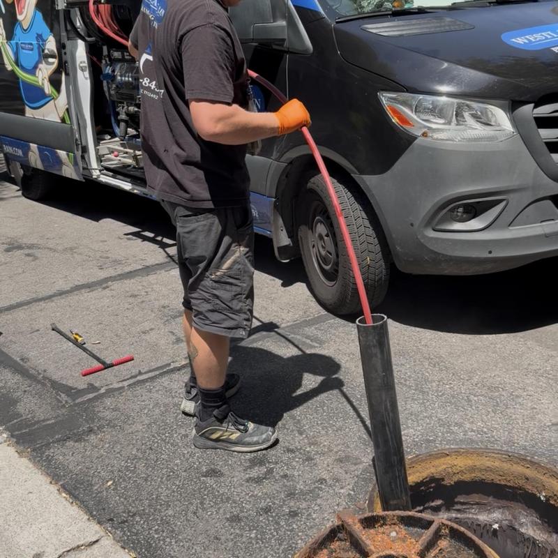 Community sewer main with hydro jet hose inserted