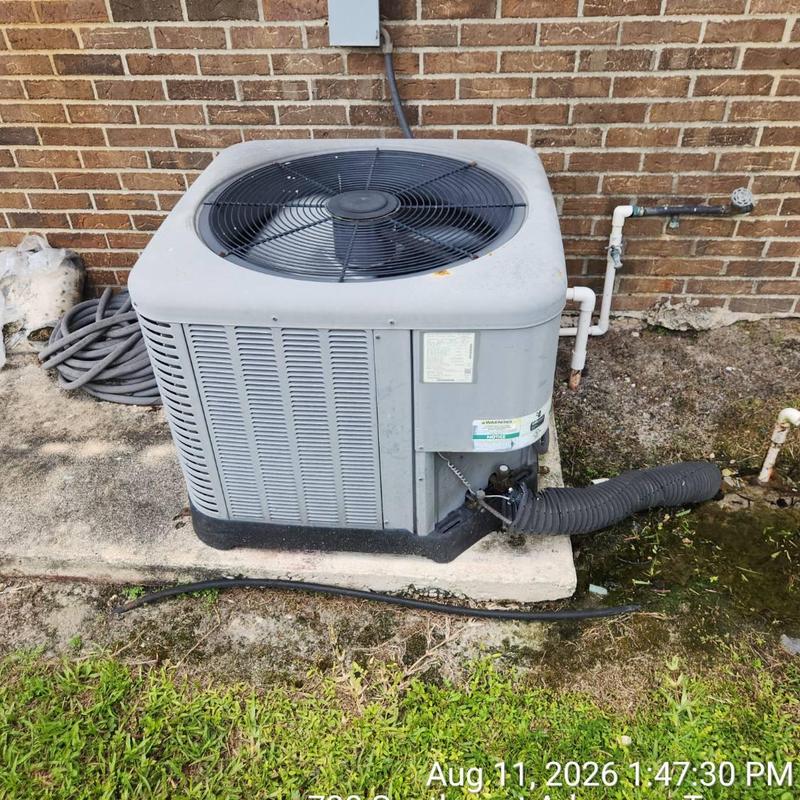 Outdoor air conditioner condenser unit by brick wall