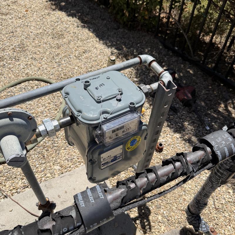 Gas meter with connected piping installation outdoors