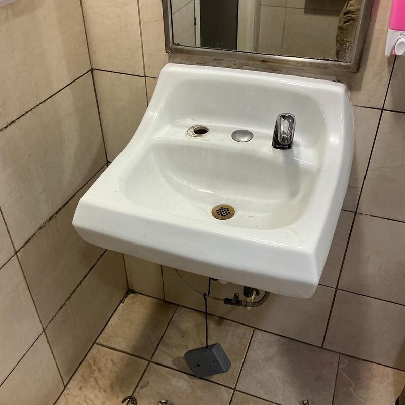 Sloan sensor faucet and wall-mounted sink in bathroom Sloan sensor faucet and wall-mounted sink in bathroom