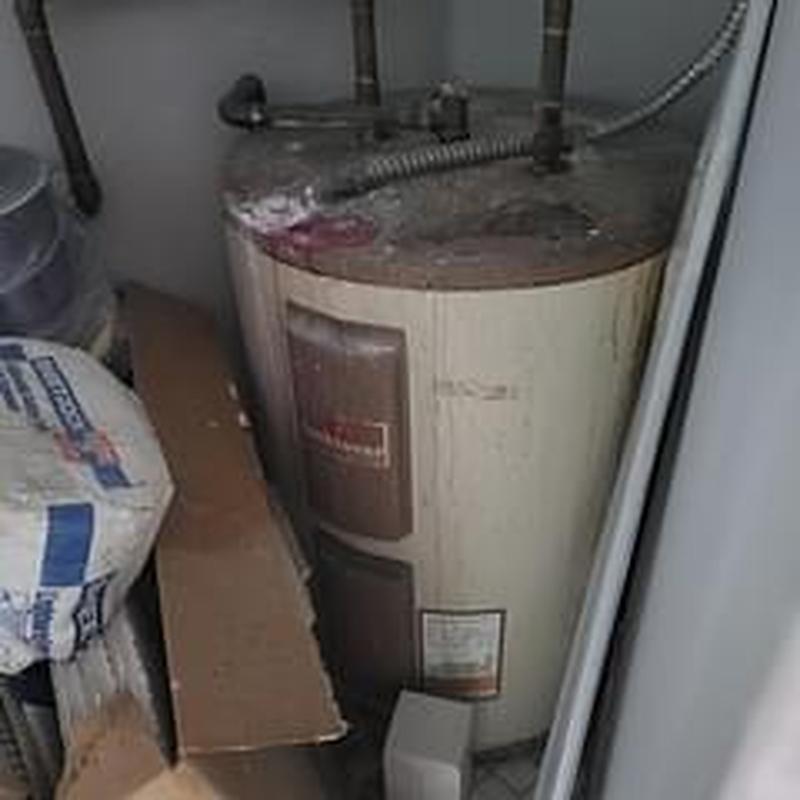 Electric water heater in closet with connected pipes
