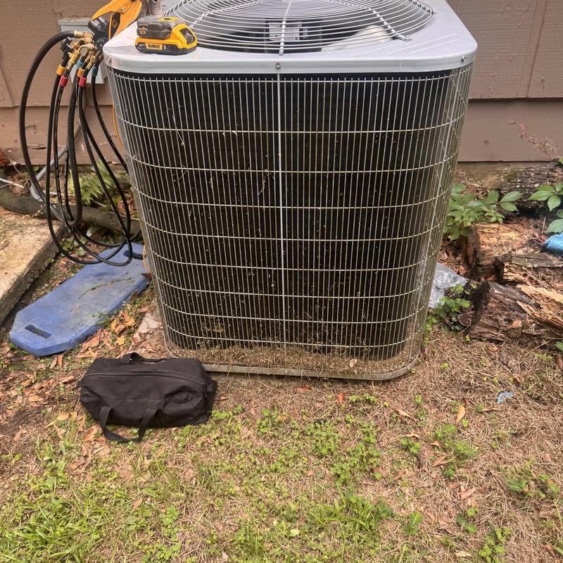 Heat pump condenser unit with attached gauges in yard