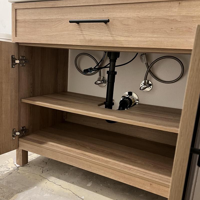 Bathroom vanity plumbing installation with fixtures and piping