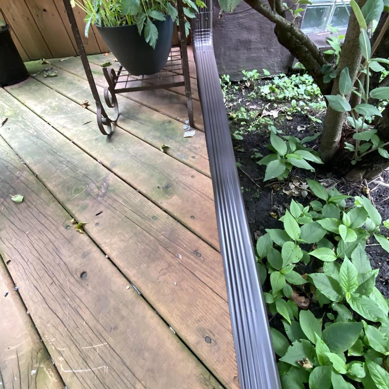 Gutter guard installation along wooden deck edge