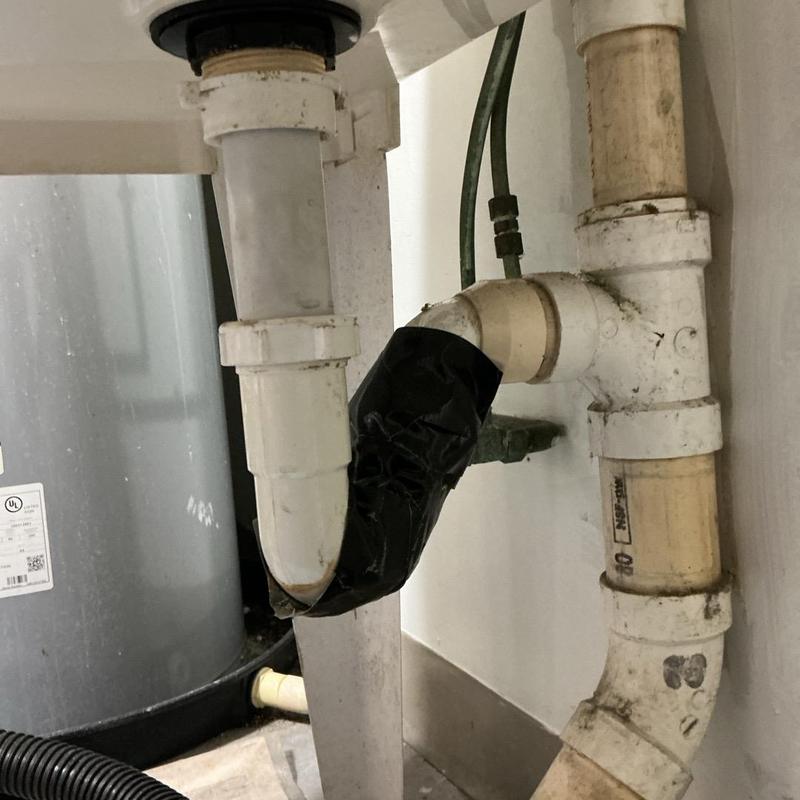 Leaking P-trap under sink with taped repair Leaking P-trap under sink with taped repair