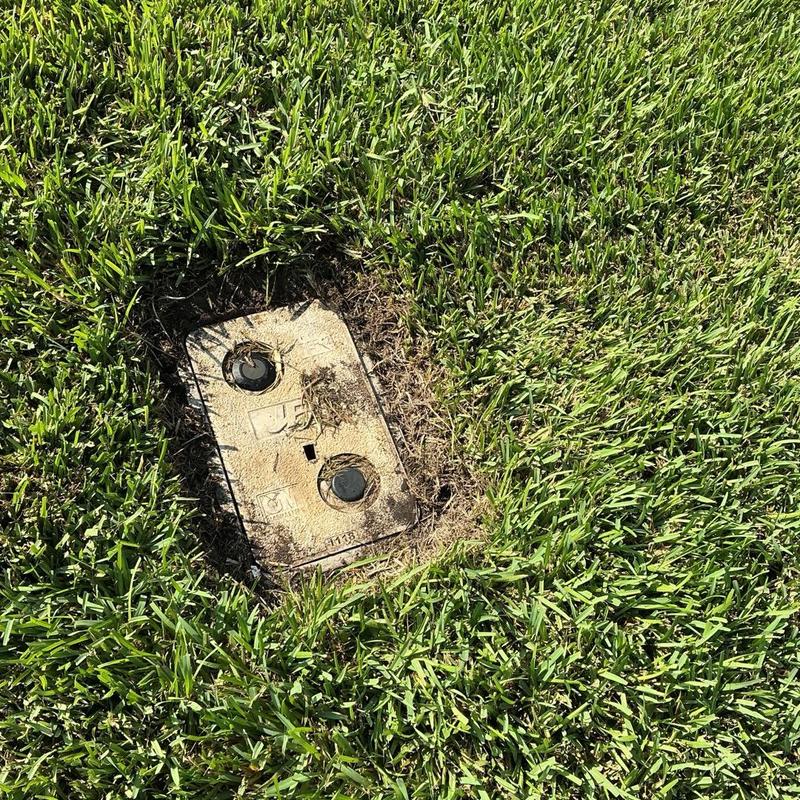 Irrigation valve box in grass lawn area Irrigation valve box in grass lawn area