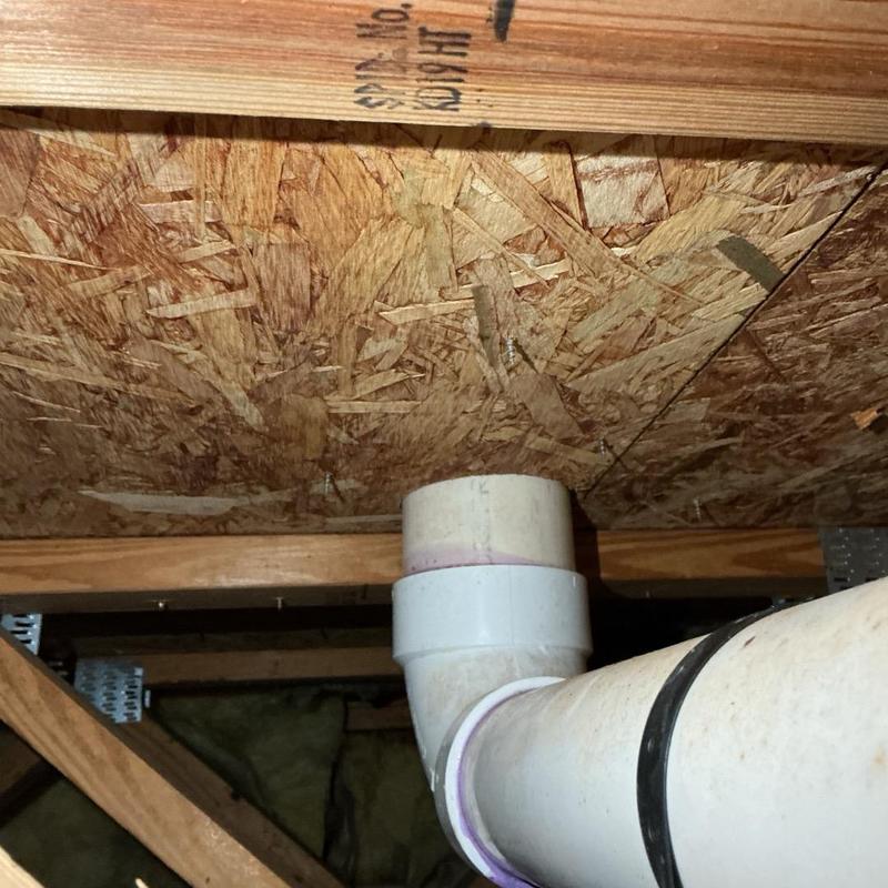 PVC drain and vent pipe under wooden floor joists PVC drain and vent pipe under wooden floor joists