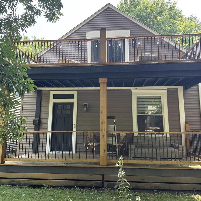 Vinyl siding on two-story house with porch railing
