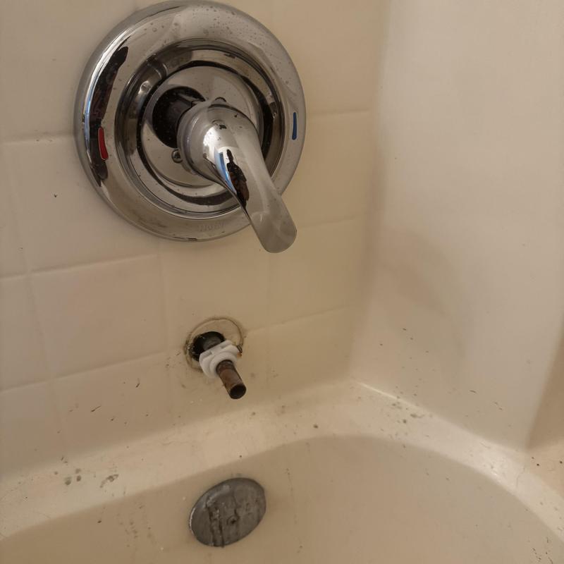 Loose tub spout with exposed plumbing in bathtub wall