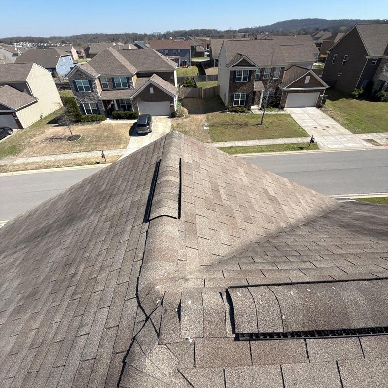 Asphalt shingle roof with vent and hail damage spots