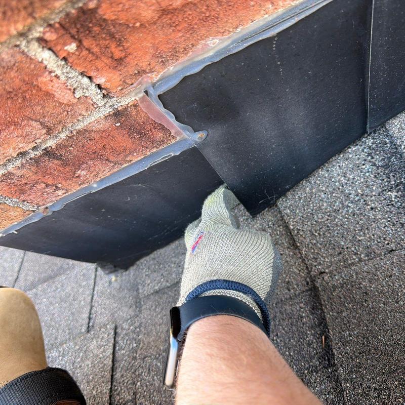 Flashing on roof edge with glove and watch visible