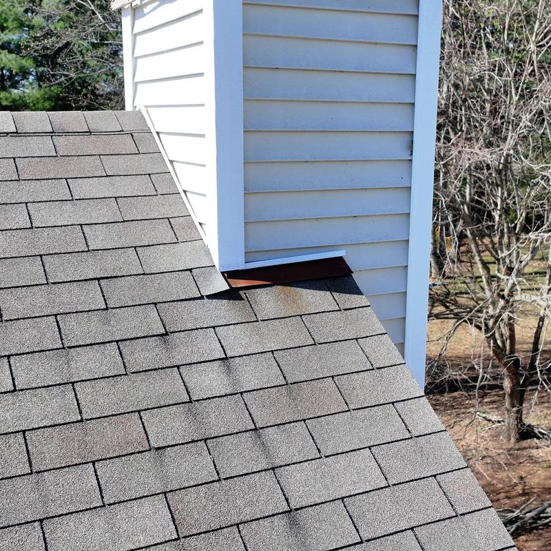 Roof shingles and flashing near chimney penetration