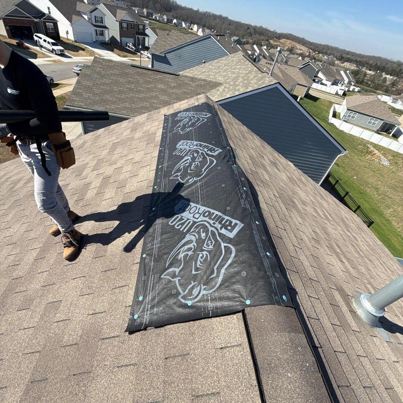 Roof ridge flashing underlayment installation on residential roof