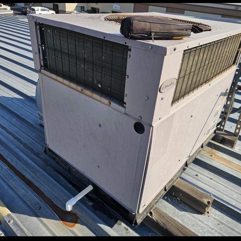 Carrier rooftop HVAC unit on commercial metal roof Carrier rooftop HVAC unit on commercial metal roof