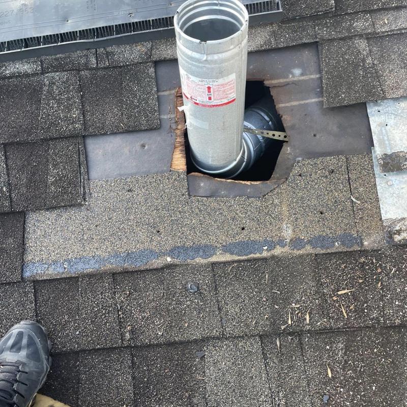 Roof ventilation pipe with damaged surrounding shingles